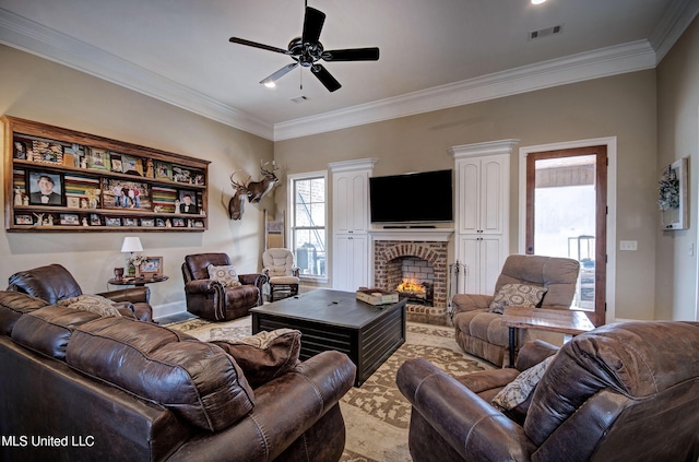 living area with visible vents, ceiling fan, a fireplace, and crown molding