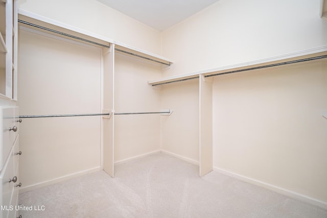 walk in closet featuring light colored carpet