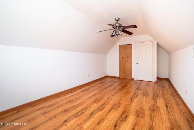 additional living space with baseboards, lofted ceiling, light wood-style floors, and a ceiling fan