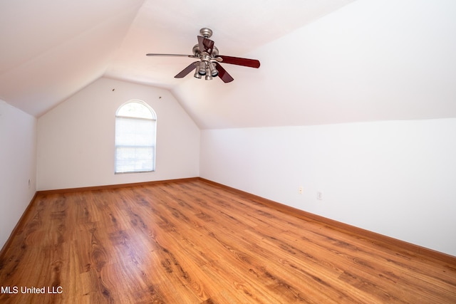 additional living space featuring a ceiling fan, lofted ceiling, wood finished floors, and baseboards