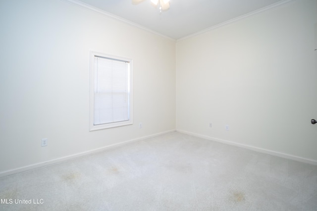 empty room with baseboards, light carpet, a ceiling fan, and crown molding