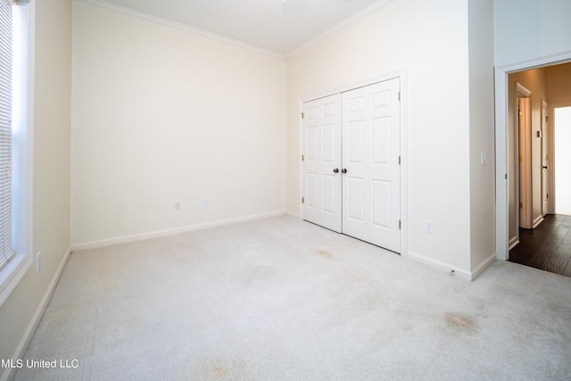 unfurnished bedroom with baseboards, carpet floors, a closet, and ornamental molding