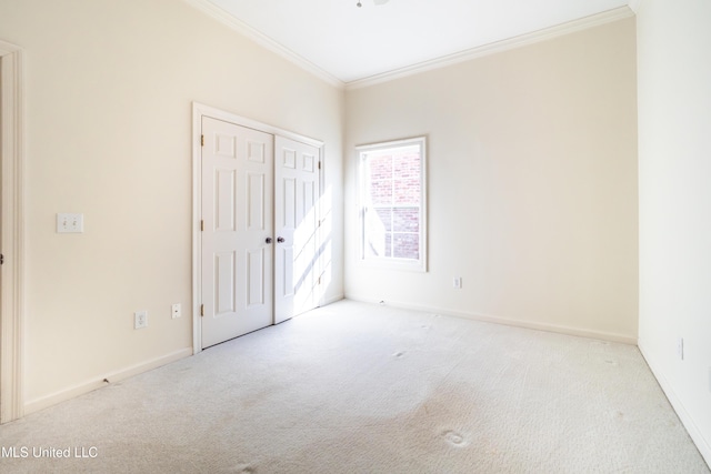 unfurnished bedroom with a closet, baseboards, ornamental molding, and carpet flooring