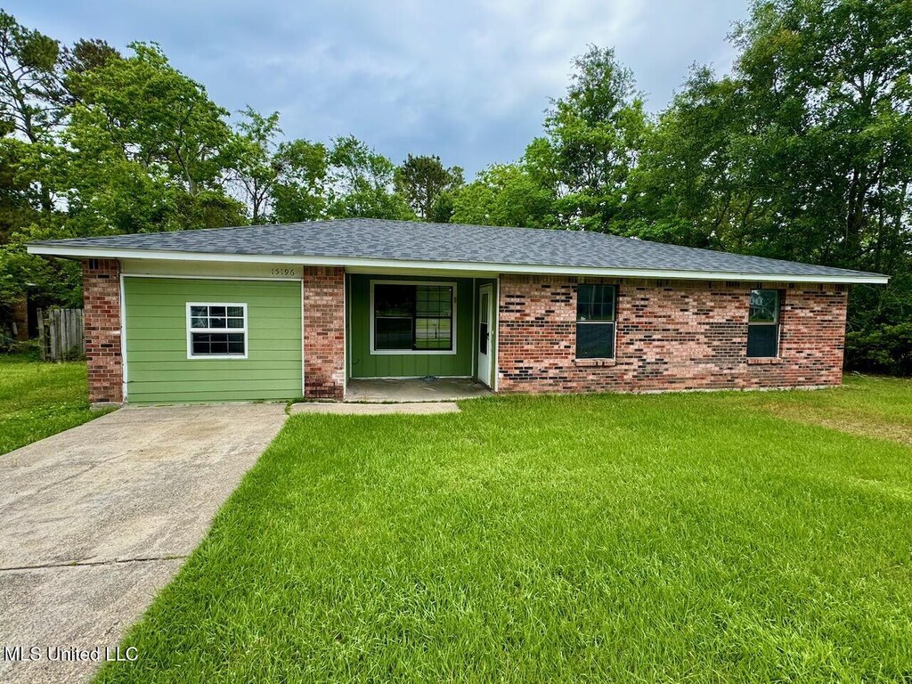 ranch-style house with driveway, a shingled roof, brick siding, and a front yard