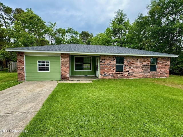 ranch-style house with driveway, a shingled roof, brick siding, and a front yard