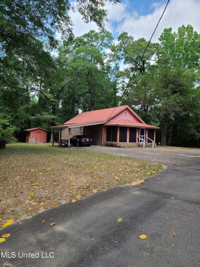 112 Lott Rd, Perkinston, MS 39573 - view of front facade featuring a carport, metal roof, an outdoor structure, and view of wooded area