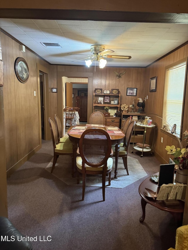 112 Lott Rd, Perkinston, MS 39573 - dining area featuring carpet flooring, wooden walls, a ceiling fan, ornamental molding, and baseboards