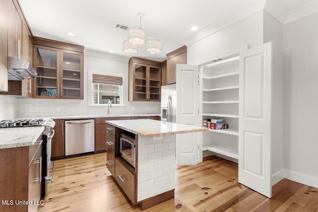 1309 Bowen Ave, Ocean Springs, MS 39564 - kitchen featuring appliances with stainless steel finishes, under cabinet range hood, light wood finished floors, backsplash, and recessed lighting
