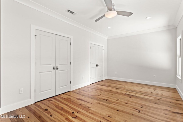 1309 Bowen Ave, Ocean Springs, MS 39564 - unfurnished bedroom featuring multiple closets, ornamental molding, light wood finished floors, baseboards, and recessed lighting