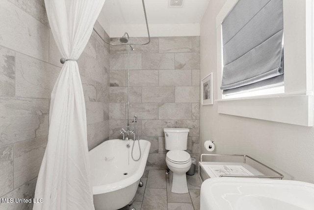 1309 Bowen Ave, Ocean Springs, MS 39564 - full bathroom with toilet, a combined bath / shower with freestanding tub, and tile walls