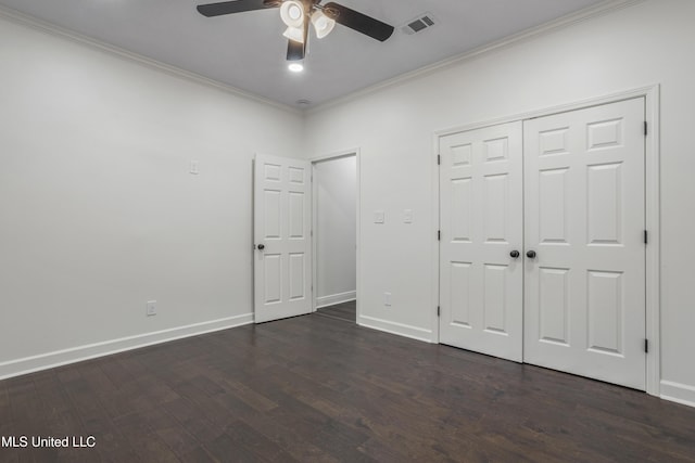 unfurnished bedroom featuring ceiling fan, ornamental molding, dark wood-type flooring, and a closet