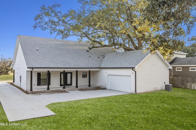 back of house featuring a lawn, a garage, covered porch, and cooling unit