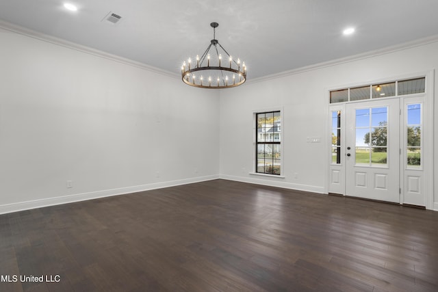 spare room featuring a chandelier, dark hardwood / wood-style floors, and ornamental molding