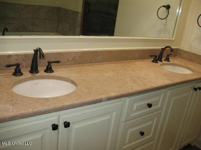 bathroom featuring a sink and double vanity