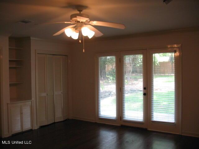 unfurnished bedroom with a ceiling fan, a closet, french doors, access to outside, and wood finished floors