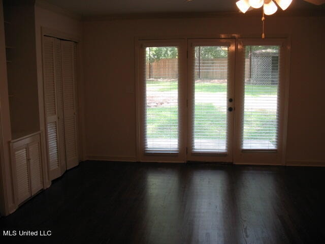 empty room with ceiling fan and dark hardwood / wood-style flooring