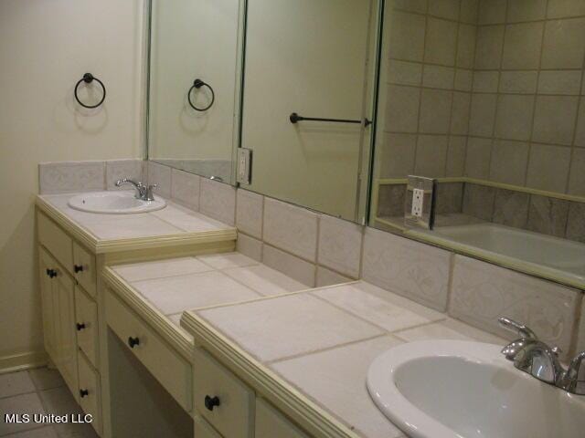 full bathroom featuring decorative backsplash, tile patterned flooring, and vanity