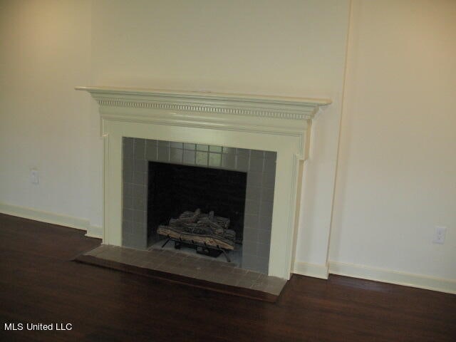 details featuring wood-type flooring and a tile fireplace