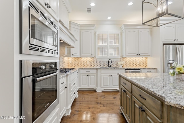 117 Belle Ct, Madison, MS 39110 - kitchen featuring appliances with stainless steel finishes, white cabinetry, light stone counters, backsplash, and dark wood-style flooring