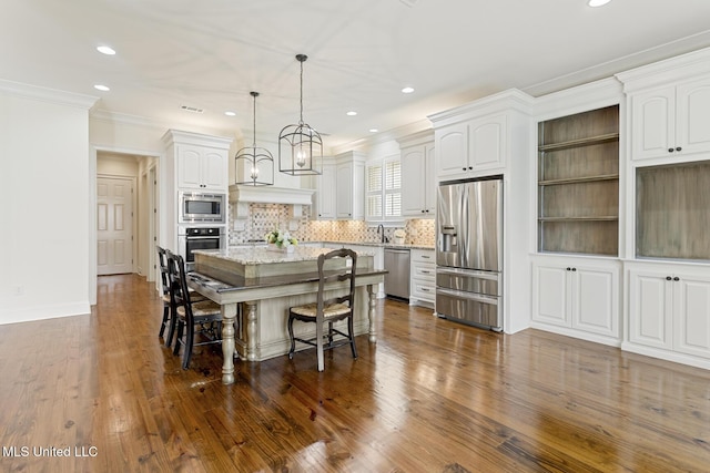 117 Belle Ct, Madison, MS 39110 - kitchen with appliances with stainless steel finishes, a kitchen island, a kitchen bar, recessed lighting, and light stone countertops