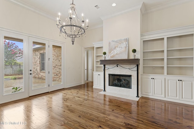 117 Belle Ct, Madison, MS 39110 - unfurnished living room with a chandelier, a fireplace with flush hearth, ornamental molding, french doors, and wood finished floors
