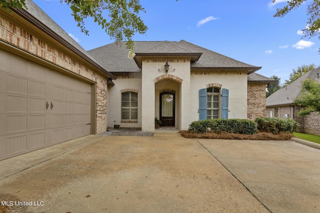 117 Belle Ct, Madison, MS 39110 - french country style house featuring brick siding, a shingled roof, concrete driveway, and a garage