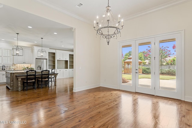 117 Belle Ct, Madison, MS 39110 - dining room featuring a chandelier, healthy amount of natural light, french doors, wood finished floors, and crown molding