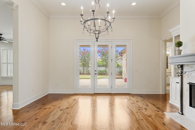 117 Belle Ct, Madison, MS 39110 - unfurnished dining area featuring a fireplace with flush hearth, ornamental molding, light wood-type flooring, a chandelier, and a ceiling fan