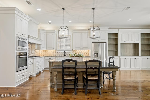 117 Belle Ct, Madison, MS 39110 - kitchen with stainless steel appliances, a center island, white cabinetry, recessed lighting, and light stone counters