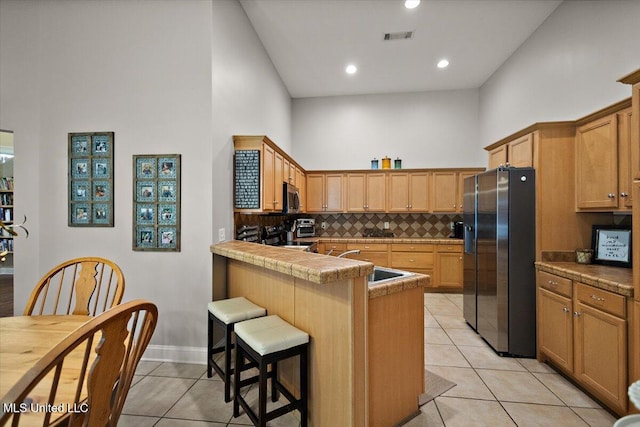 1510 Independence Blvd, Flowood, MS 39232 - kitchen with stainless steel appliances, high vaulted ceiling, light tile patterned floors, a peninsula, and backsplash