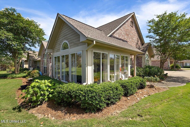 1510 Independence Blvd, Flowood, MS 39232 - view of property exterior featuring brick siding, roof with shingles, a sunroom, and a yard