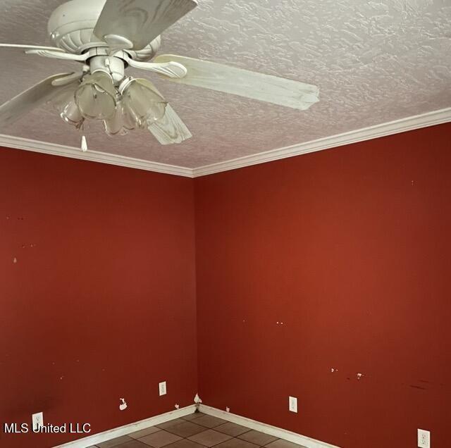 unfurnished room featuring a textured ceiling, ceiling fan, and ornamental molding