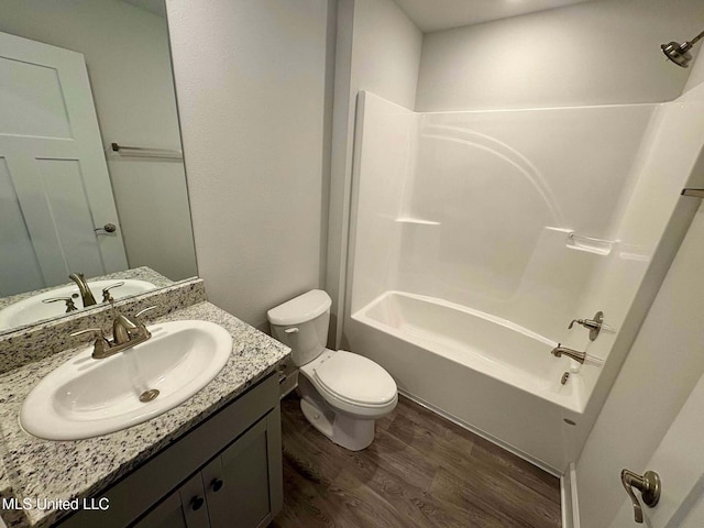 bathroom with toilet, wood finished floors, bathing tub / shower combination, and vanity