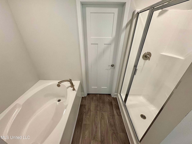 full bathroom featuring a shower stall, wood finished floors, and a garden tub
