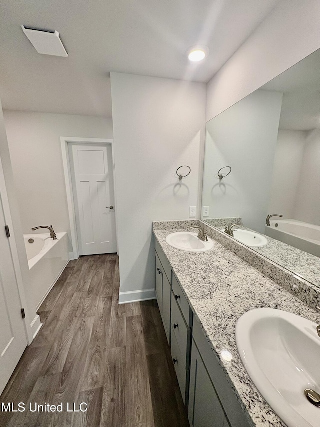 18071 Tiffany Renee Dr, Gulfport, MS 39503 - full bathroom with a bath, double vanity, wood finished floors, and baseboards