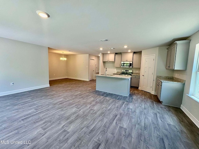 kitchen with a notable chandelier, baseboards, dark wood-type flooring, stainless steel appliances, and a sink