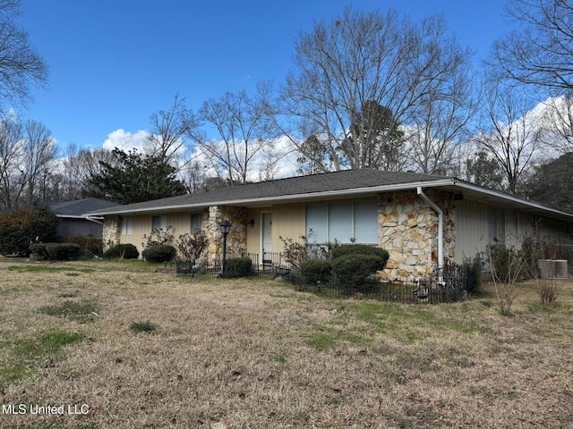 view of front facade with stone siding and a front lawn