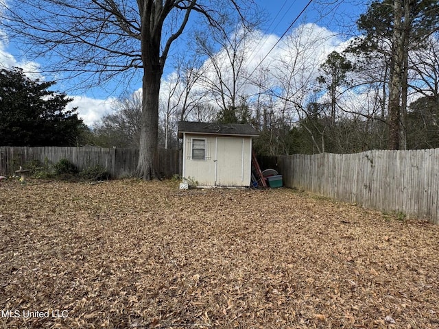 view of yard featuring an outbuilding, a storage shed, and a fenced backyard