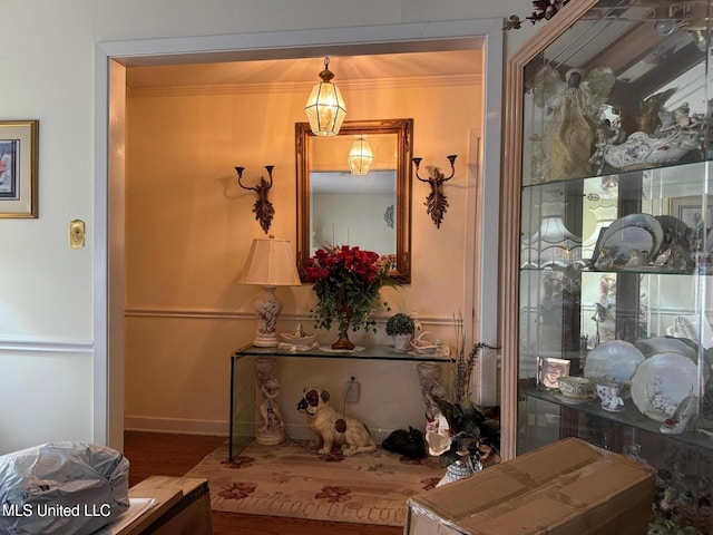 hallway with baseboards, crown molding, and wood finished floors