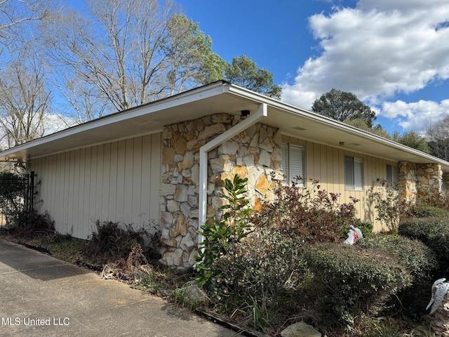 view of side of home featuring stone siding