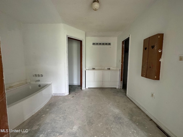 bathroom with vanity, concrete floors, and a tub to relax in