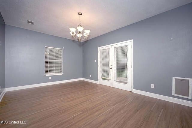 8002 Martin Bluff Rd, Gautier, MS 39553 - empty room featuring a chandelier, dark wood-style floors, and french doors