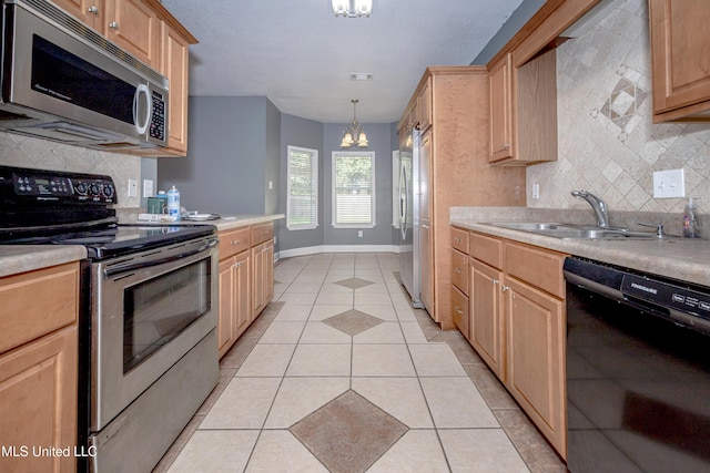 8002 Martin Bluff Rd, Gautier, MS 39553 - kitchen featuring appliances with stainless steel finishes, light brown cabinetry, tasteful backsplash, a chandelier, and light countertops