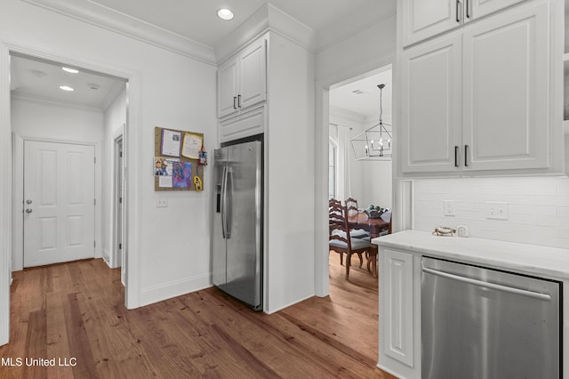 131 Camden Trl, Madison, MS 39110 - kitchen featuring appliances with stainless steel finishes, crown molding, a chandelier, white cabinets, and dark wood-type flooring