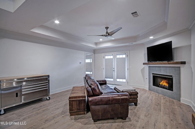 living room featuring a fireplace, french doors, and a raised ceiling