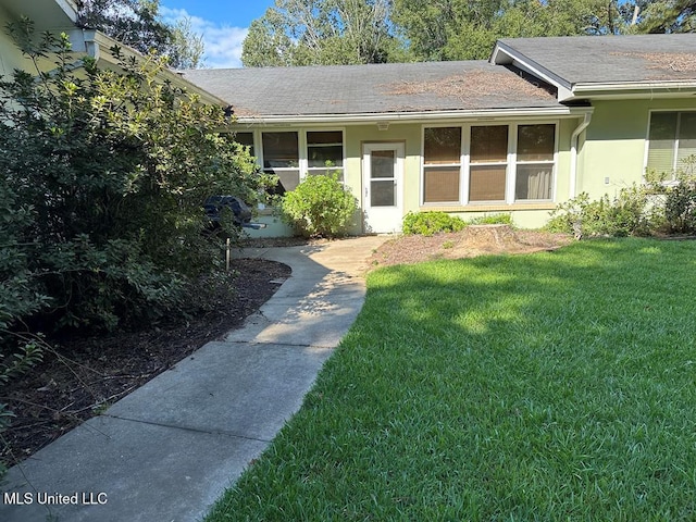 view of exterior entry with a lawn