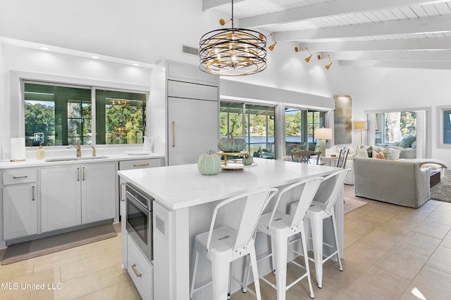 kitchen with lofted ceiling with beams, sink, and a wealth of natural light