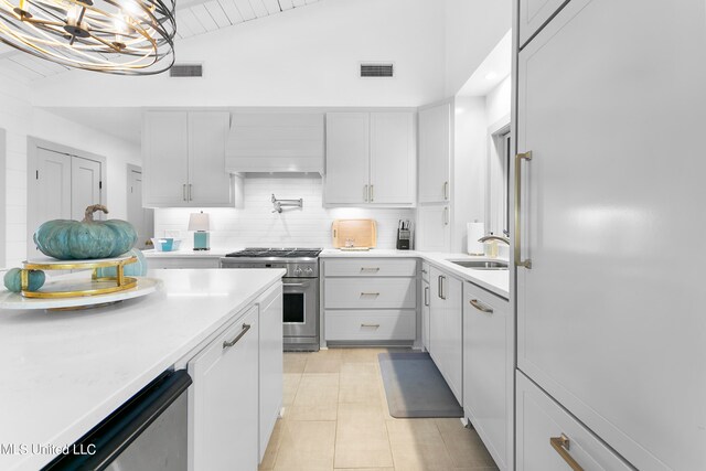 kitchen featuring sink, high end range, white cabinetry, vaulted ceiling, and custom exhaust hood