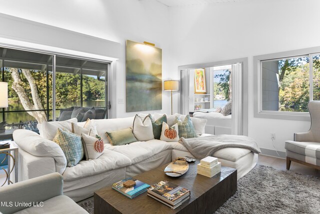 tiled living room featuring a high ceiling and plenty of natural light