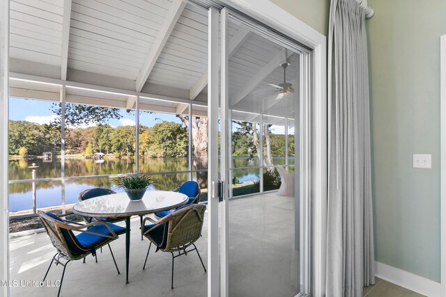 sunroom with a water view, ceiling fan, and beamed ceiling